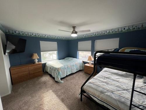 a bedroom with two beds and a ceiling fan at 3-bedroom house Rockaway Beach in Rockaway Beach