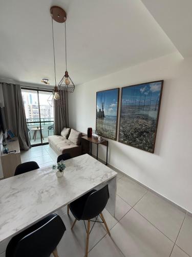 a living room with a marble table and chairs at Smart Stay Experience in Maceió