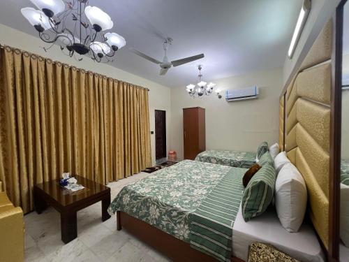 Un dormitorio con dos camas y una lámpara de araña. en Hotel beachside, en Karachi