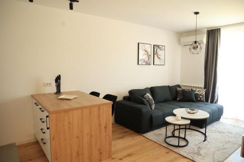 a living room with a couch and a table at Stylish Lumen Apartment Luxury Stay and Free Parking in Sarajevo