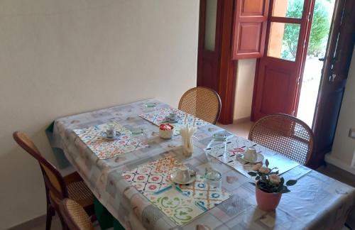 a table with a table cloth on it with chairs at B&B Antica Villa in Quartu SantʼElena