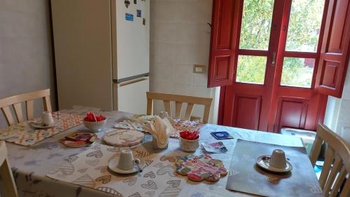 a table in a kitchen with a red door at B&B Antica Villa in Quartu SantʼElena