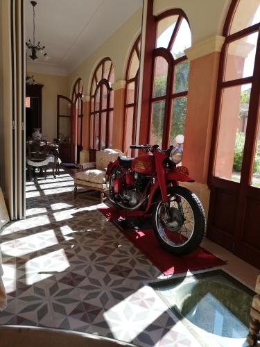 a red motorcycle parked in a room with windows at B&B Antica Villa in Quartu SantʼElena