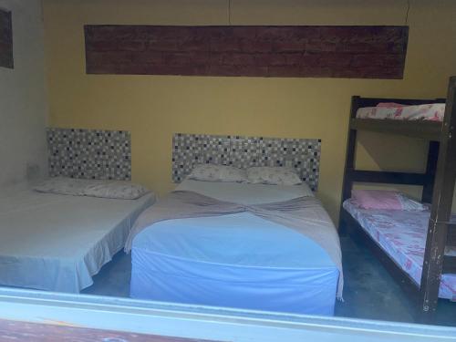 two beds in a room with two bunk beds at Sítio Estrela da Manhã Hospedagem e Lazer in Palmeiras