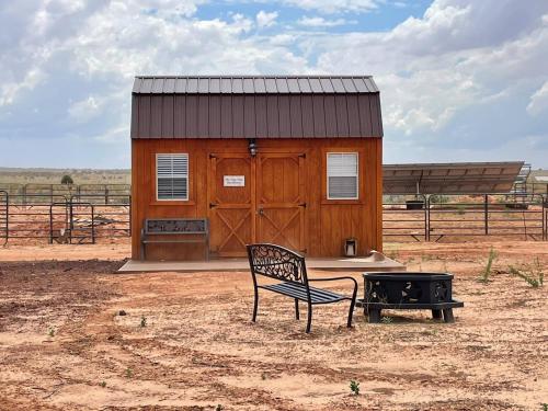 a chair sitting in front of a small building at Tiny Tiny Bunkhouse in Cane Beds