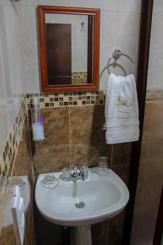 a bathroom sink with a mirror and a towel at Casa Romano in Tlatlauquitepec