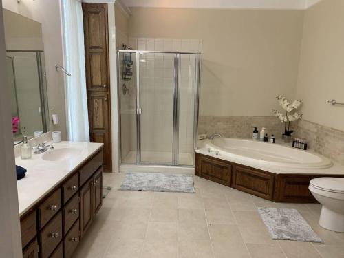 a bathroom with a tub and a shower and a toilet at Temple View Inn with Music Studio in Independence