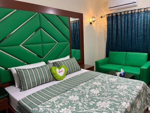 Un dormitorio con una cama grande con cabecero verde. en Hotel beachside, en Karachi
