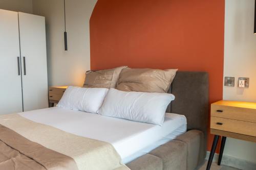 a bed with white pillows and a couch in a room at Signature View Apartment in Accra