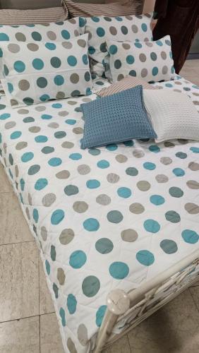 a bed with polka dot sheets and pillows on it at Apartman Trebinje sa parkingom in Trebinje
