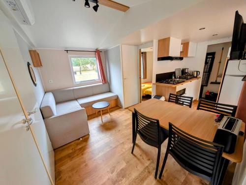 una sala da pranzo e una cucina con tavolo e sedie di Mobil-Home 4-6 personnes camping 4 étoiles a Capbreton