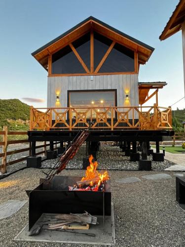a log cabin with a fire in front of it at Cabañas Los Manzanos in Cholila