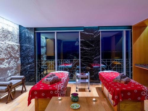 a living room with two beds and a table at Movenpick Hotel & Convention Centre KLIA in Sepang