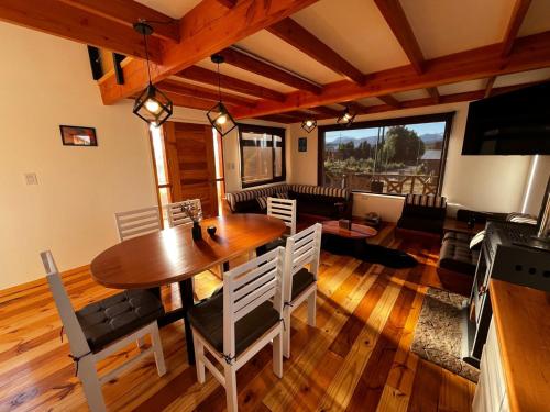 un soggiorno con un tavolo di legno e un divano di Cabañas Los Manzanos a Cholila