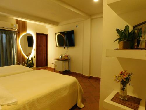 a hotel room with a bed and a vase of flowers at La casa del Colibri in Mompos
