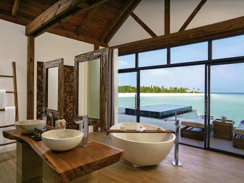 a bathroom with two sinks and a large window at Kuredhivaru Resort and Spa - Maldives in Manadhoo