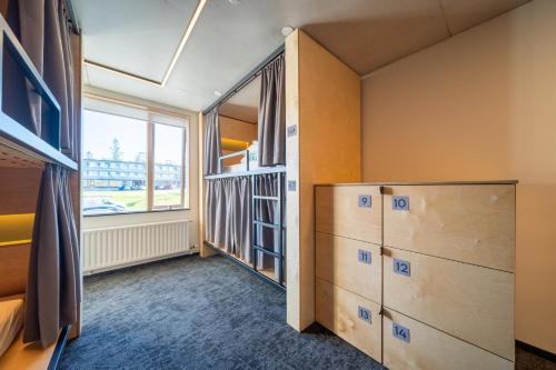 a bedroom with drawers and a window in a room at Dalur - HI Eco Hostel in Reykjavík