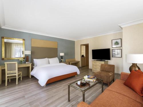 a hotel room with a bed and a couch at Mövenpick Resort Petra in Wadi Musa