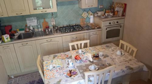 a kitchen with a table and chairs with a tea set at Oasi Ottocento in Quartu SantʼElena