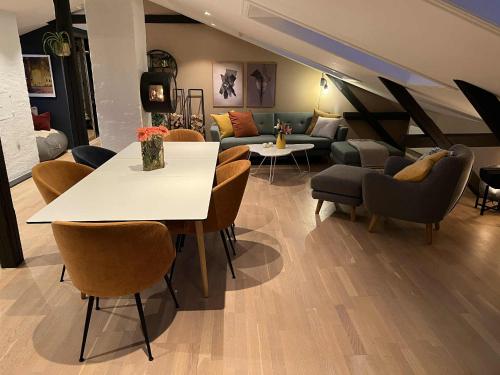 a living room with a table and chairs and a couch at Stylish Grünerløkka penthouse with rooftop terrace in Oslo