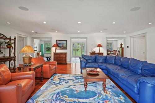 a living room with a blue couch and a table at Chilmark Luxury Quansoo Beach Access-4br in West Tisbury