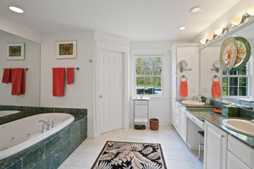 a bathroom with two sinks and a tub and a large tub at Chilmark Luxury Quansoo Beach Access-4br in West Tisbury