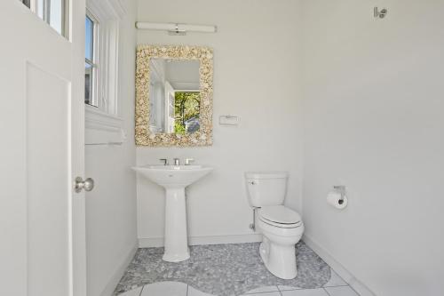 a white bathroom with a toilet and a sink at Chilmark Luxury Quansoo Beach Access-4br in West Tisbury