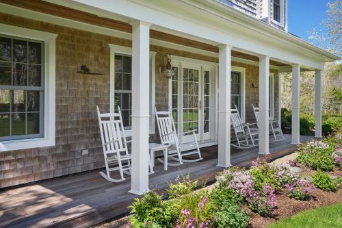 a porch with white chairs on a house at Chilmark Luxury Quansoo Beach Access-4br in West Tisbury