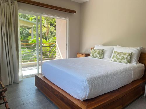 a bedroom with a large bed and a balcony at Uvita Paradise , Walk to the Ballena Beach in Uvita