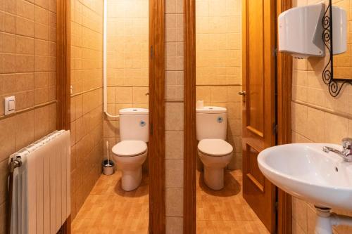 a bathroom with two toilets and a sink at Alberg Xerta - Allotjament rural in Xerta