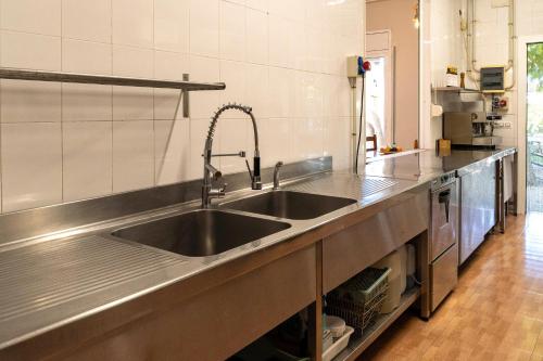 a kitchen with a stainless steel counter top with a sink at Alberg Xerta - Allotjament rural in Xerta