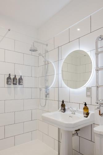 a white bathroom with a sink and a shower at Grace's Guesthouse Room 5 in Tring