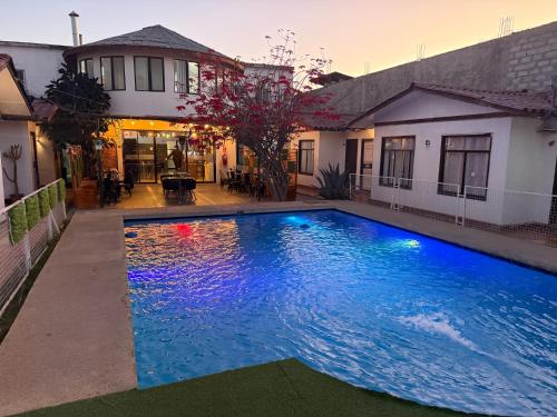 a large swimming pool in front of a house at Hotel Cecil in Vallenar