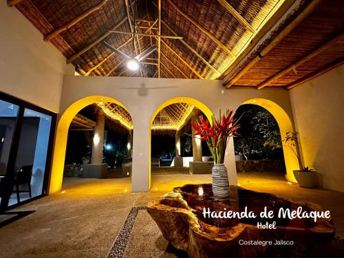 a lobby with a table with a vase of flowers at Hotel Hacienda de Melaque in San Patricio Melaque