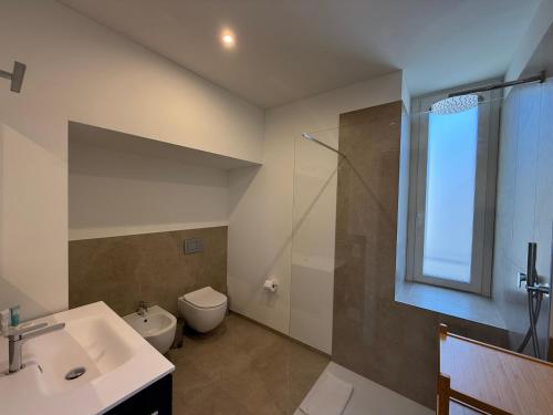 a bathroom with a sink and a toilet and a shower at Schloss Locarno - Self Check-In in Locarno