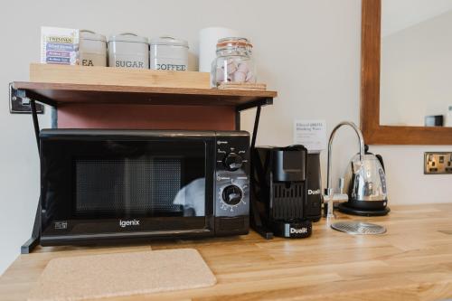 a microwave sitting on top of a kitchen counter at Grace's Guesthouse Room 4 in Tring