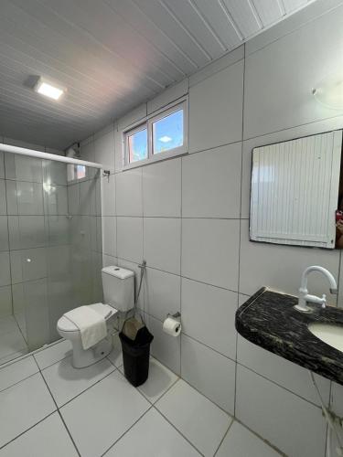 a bathroom with a toilet and a shower and a sink at Pousada e Restaurante Altas Horas Beach in Itapipoca