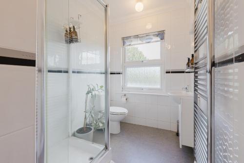 a bathroom with a shower and a toilet and a sink at Grace's Guesthouse Room 3 in Tring