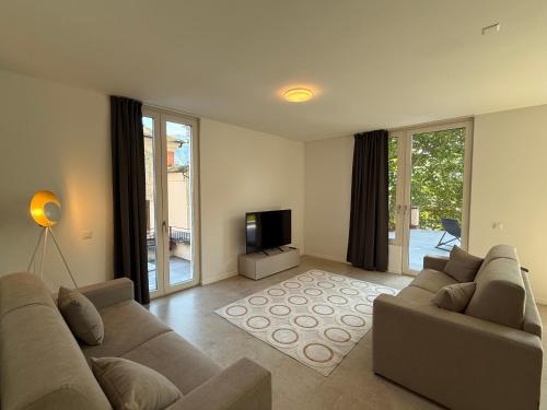a living room with a couch and a television at Schloss Locarno - Self Check-In in Locarno