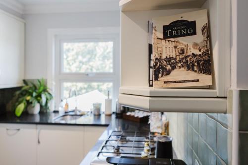 a kitchen with a stove with a picture of a group of people at Grace's Guesthouse Room 3 in Tring