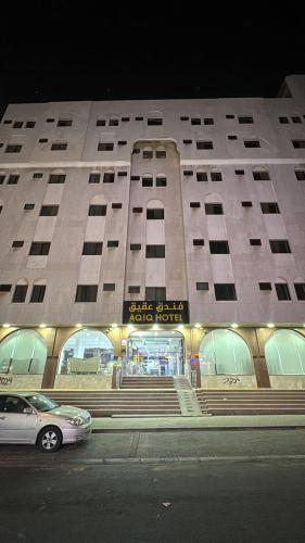 a building with a car parked in front of it at التطوير الحضري فندق عقيق شارع ابراهيم الخليل in Al Masfalah