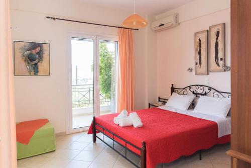 a bedroom with a red bed and a window at Villa Tapia in Methoni