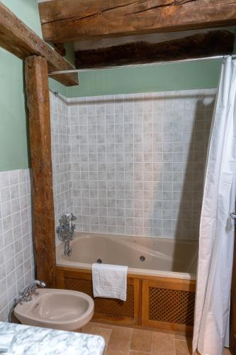 a bathroom with a tub and a toilet and a sink at Hotel Rincón Castellano in Cuéllar