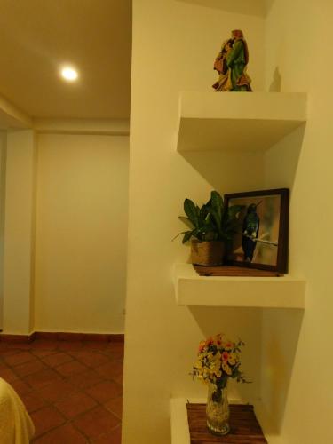 a room with some flowers in a vase on a shelf at La casa del Colibri in Mompos