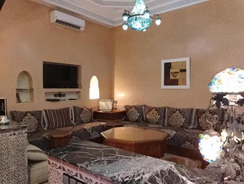 una sala de estar con un sofá y una mesa en Riad Yousra, en Marrakech