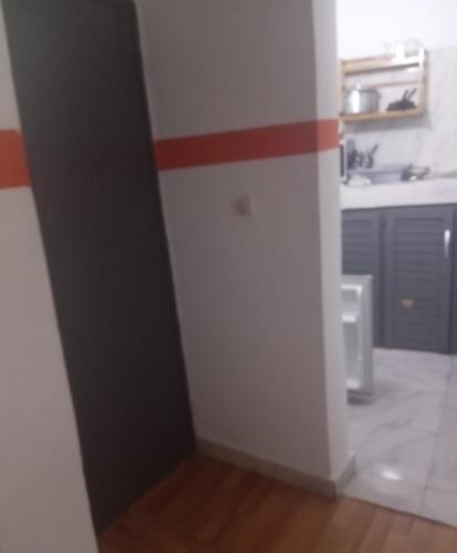 una cucina con una striscia rossa sul muro di Residence Chris a Abidjan