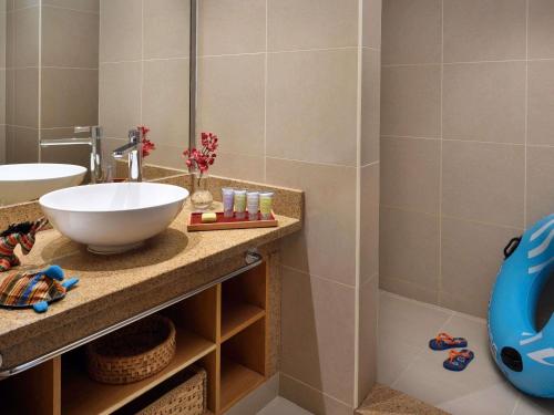 a bathroom with a sink and a mirror at Mövenpick Resort & Spa Tala Bay Aqaba in Aqaba