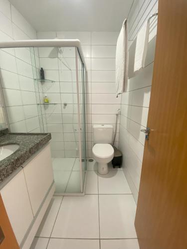 a bathroom with a toilet and a glass shower at Flat superior no Monte Castelo Condomínio in Gravatá