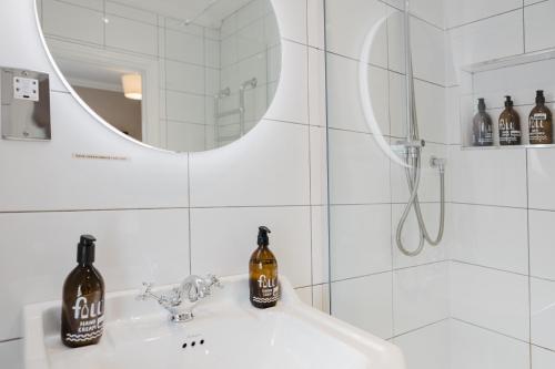 a bathroom with a sink with two bottles on it at Grace's Guesthouse Room 1 in Tring