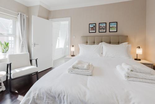 a bedroom with a large white bed with towels on it at Grace's Guesthouse Room 1 in Tring